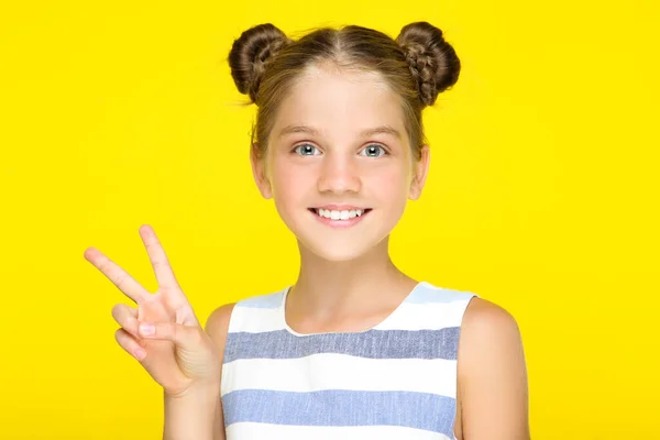 Young beautiful girl showing two fingers on yellow background — 스톡 사진