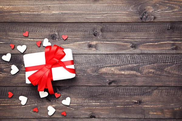 Caja de regalo con cinta y corazones en mesa de madera — Foto de Stock