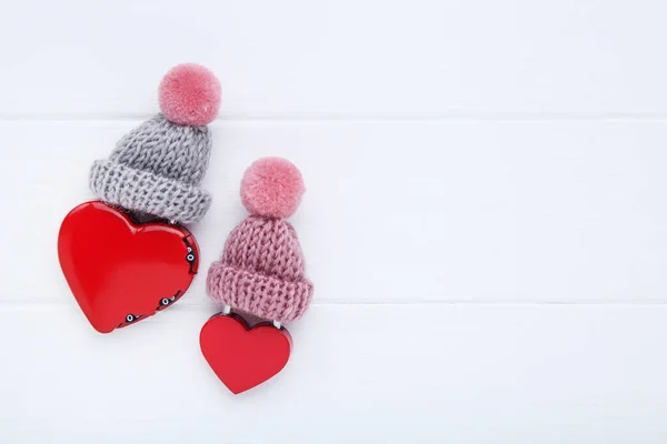 Candados en forma de corazón de San Valentín con sombreros en respaldo de madera blanca —  Fotos de Stock