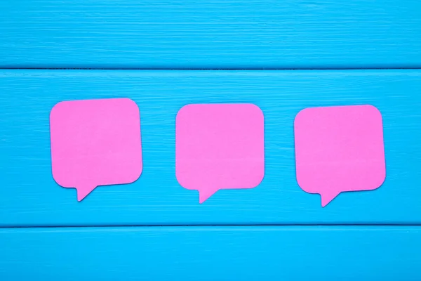 Bulles de discours en papier sur table en bois bleue — Photo