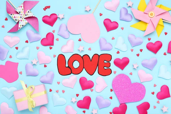 Coeurs de Saint-Valentin avec boîte cadeau, moulins à vent en papier et mot Love on — Photo