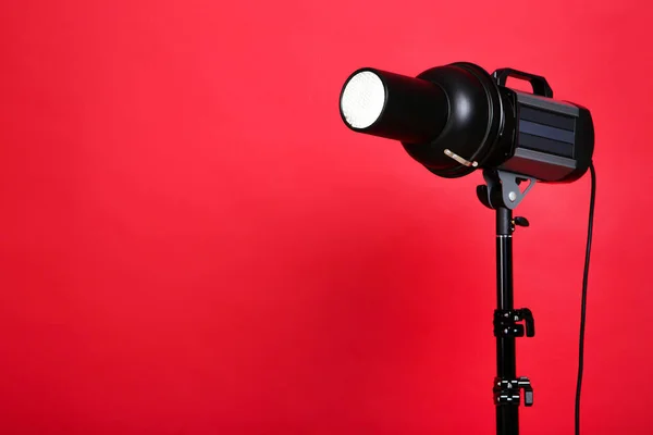 Illuminazione da studio con treppiede su sfondo rosso — Foto Stock