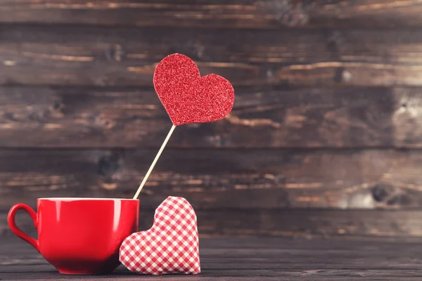 Υφασμάτινη καρδιά με κόκκινο κύπελλο στο ξύλινο τραπέζι — Φωτογραφία Αρχείου