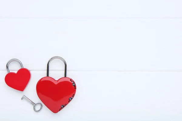 Valentine heart shaped padlocks with key on white wooden backgro — 스톡 사진