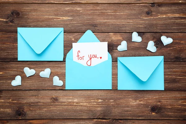 Sobres de papel azul con corazones y texto para ti en madera marrón —  Fotos de Stock