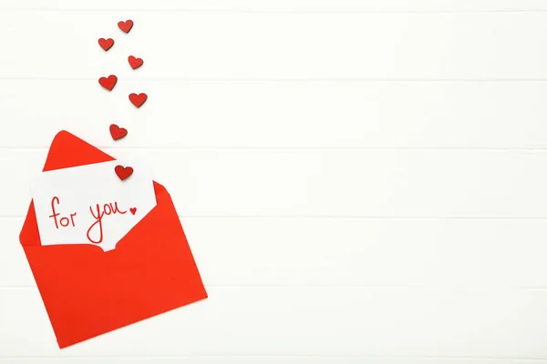 Paper envelope with red hearts and text For You on white wooden — 스톡 사진