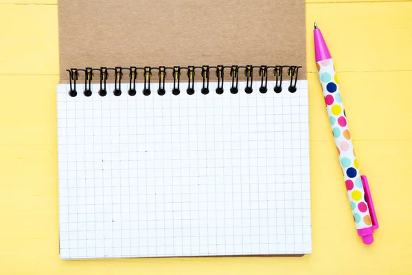 Blanco notitieblok met pen op gele houten tafel — Stockfoto