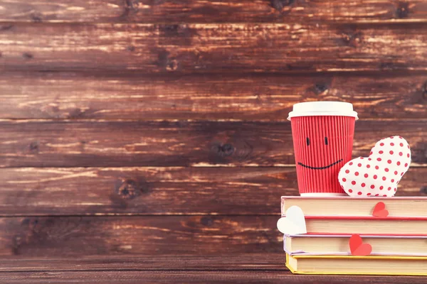 赤いカップと茶色の本のスタックを持つファブリックと紙の心 — ストック写真