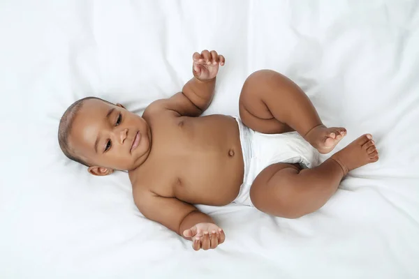 Bebé americano acostado en la cama blanca —  Fotos de Stock