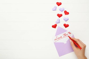 Kadın eli Sevgi 'yi kağıda renkli bir zarf ile yazıyor.