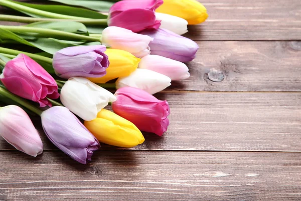 Bouquet of tulip flowers on brown wooden table — Stock Photo, Image