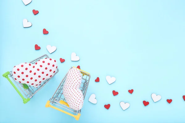 Corazones de tela con carritos de compras sobre fondo azul — Foto de Stock