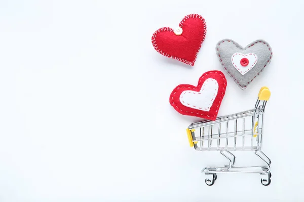 Corazones de tela con carrito de compras sobre fondo blanco — Foto de Stock