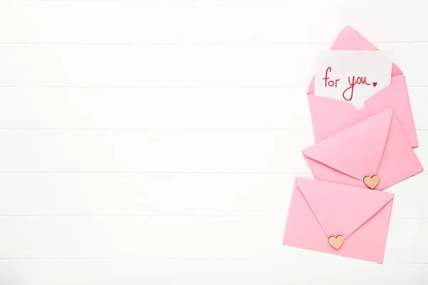Rosa Papierumschläge mit Herzen und Text für Sie auf weißem Holz — Stockfoto
