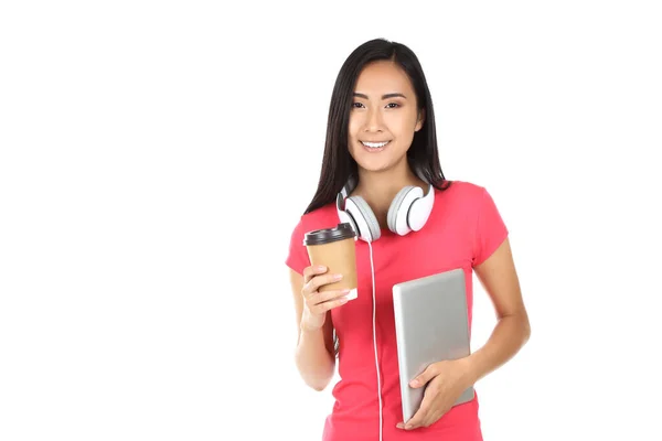 Jonge vrouw met tablet pc, koptelefoon en papieren beker op witte ba — Stockfoto