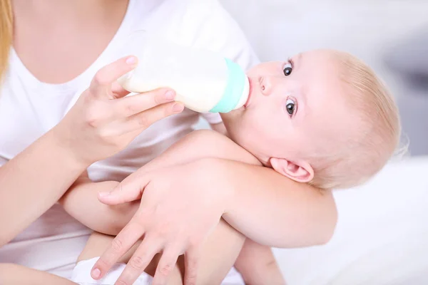 Jovem mãe alimentando seu filho bebê em casa — Fotografia de Stock