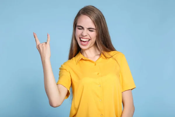 Ung vacker flicka visar en gest på blå bakgrund — Stockfoto