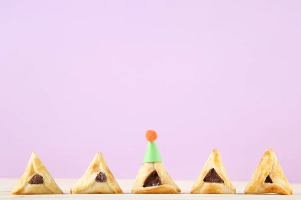 Purim semester sammansättning. Cookies med papperslock på rosa bakgr — Stockfoto