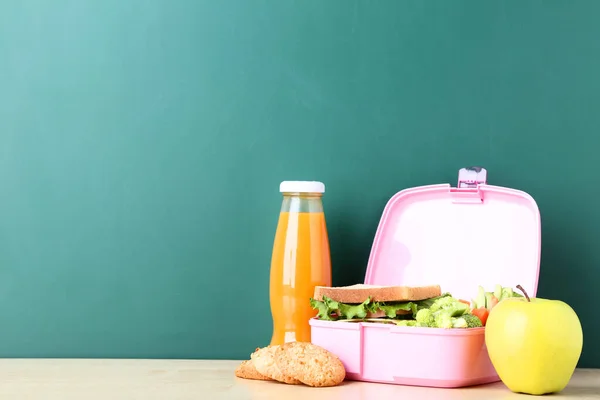 Школьная коробка с бутербродами и овощами на доске — стоковое фото