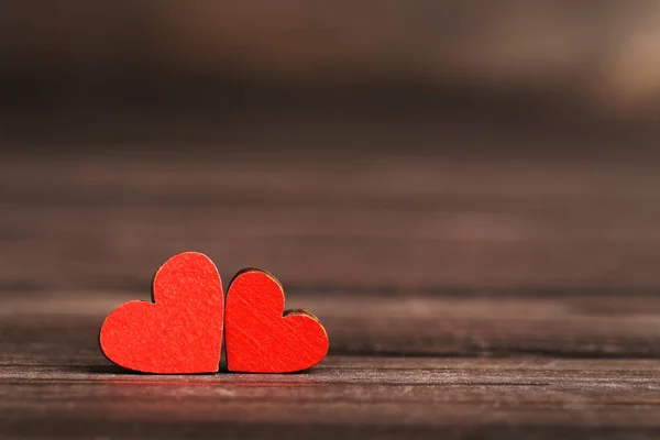 Red hearts on brown wooden table — Stock Photo, Image