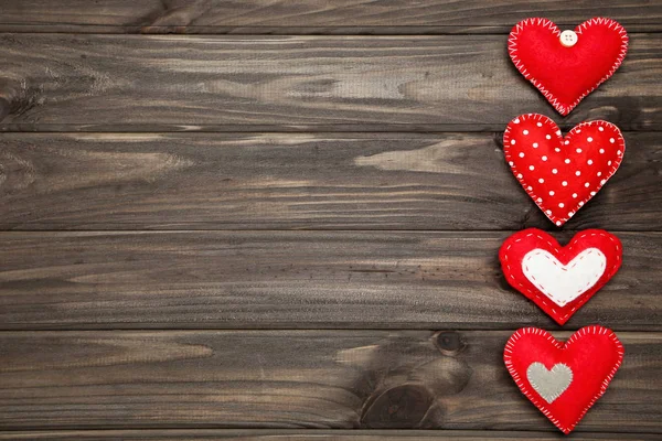 Corazones de tela sobre mesa de madera marrón — Foto de Stock