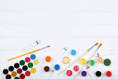 Renkli gouache beyaz ahşap masa üzerinde boya ve fırça