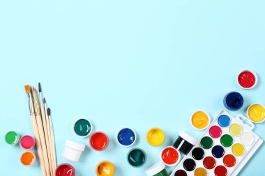 Renkli gouache mavi arka planda boya ve fırçalar