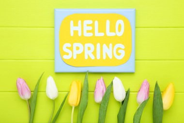 Yazılı lale çiçekleri Merhaba yeşil ahşap masadaki bahar