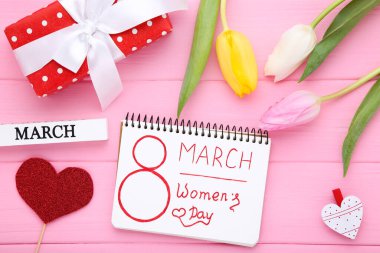 8 Mart Kadınlar Günü Lale çiçekleri ve pembe ahşap masada hediye paketi