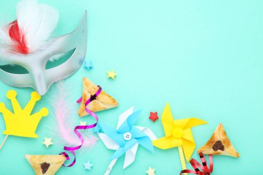Purim tatil kompozisyonu. Mavi arka planda parti malzemeleri olan kurabiyeler