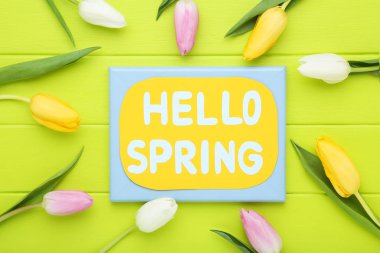 Yazılı lale çiçekleri Merhaba yeşil ahşap masadaki bahar