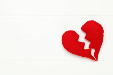 Beyaz ahşap masada kırık bir kalp.