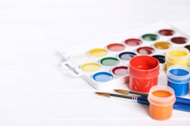 Renkli gouache beyaz ahşap masa üzerinde boya ve fırça