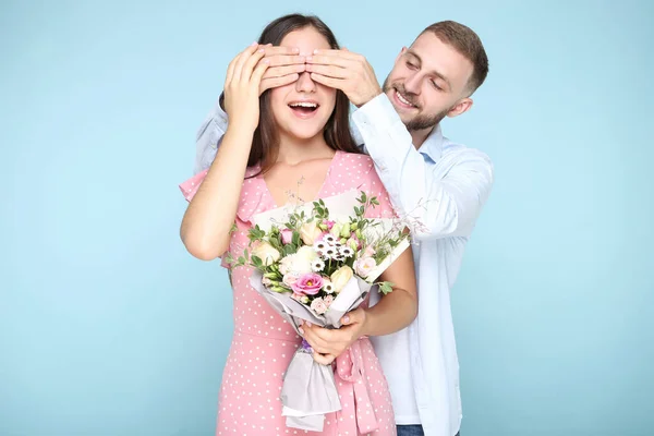 幸福的年轻夫妇 蓝色背景的花束 — 图库照片