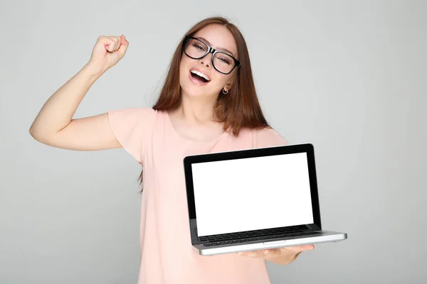 Tânără Femeie Care Arată Ecranul Laptopului Gol Fundal Gri — Fotografie, imagine de stoc