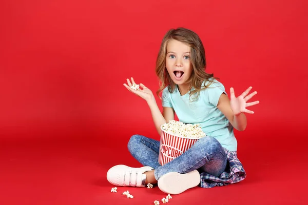 Chica Joven Con Palomitas Maíz Cubo Sentado Sobre Fondo Rojo —  Fotos de Stock