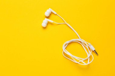 Sarı arka planda beyaz kulaklıklar