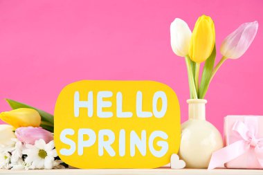 Tulip, mesajlı kasımpatı çiçekleri Merhaba bahar ve pembe arka planda hediye kutusu