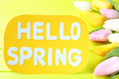 Yazılı lale çiçekleri Merhaba yeşil ahşap masadaki bahar