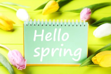 Yazılı lale çiçekleri Merhaba yeşil ahşap masadaki bahar