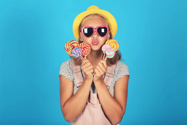 Junges Mädchen Mit Sonnenbrille Hut Und Lutschern Auf Blauem Hintergrund — Stockfoto