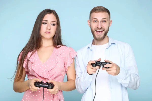 Mavi Arka Planda Joysticklerle Bilgisayar Oyunu Oynayan Mutlu Genç Çift — Stok fotoğraf