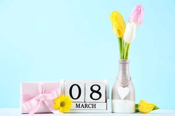 带有郁金香花和蓝色背景礼品盒的立方体日历 — 图库照片