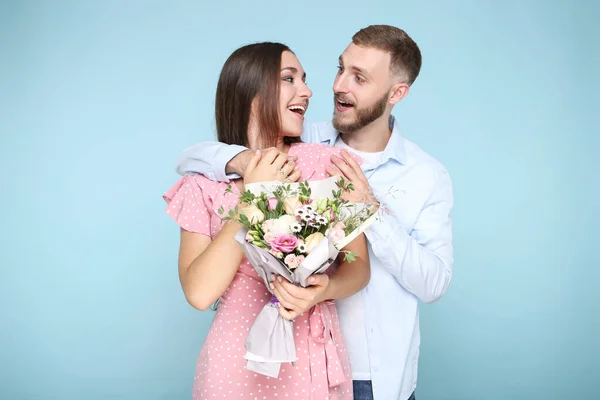 Feliz Pareja Joven Con Ramo Flores Sobre Fondo Azul — Foto de Stock