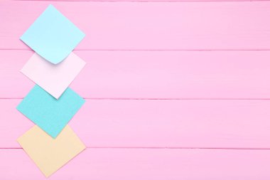 Kağıt yapışkan notlar pembe ahşap masa üzerinde