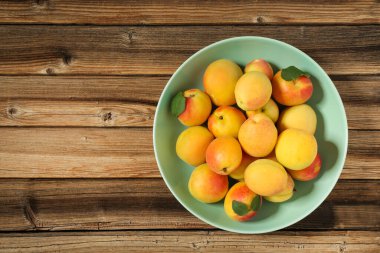 Kahverengi ahşap masa üzerinde tabak tabaktatlı kayısı