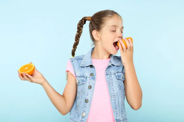 Menina Comendo Frutas Laranja Fundo Azul — Fotografia de Stock
