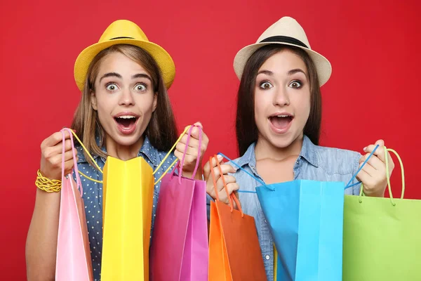Молодые Счастливые Девушки Пакетами Покупок Красном Фоне — стоковое фото