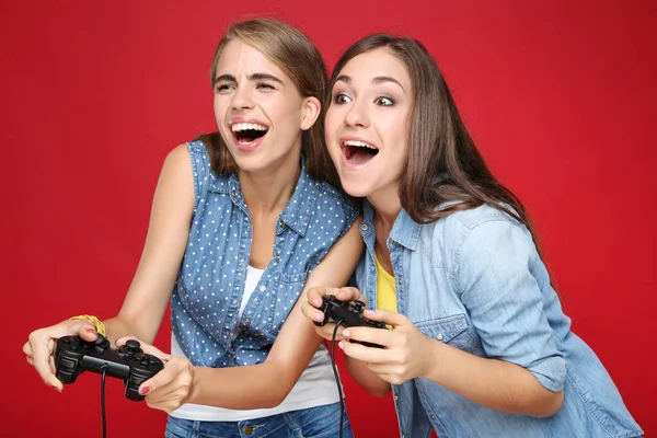 Jong Gelukkig Vriendinnen Spelen Computer Spel Met Joysticks Rode Achtergrond — Stockfoto