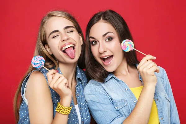 Jovens Namoradas Felizes Com Pirulitos Fundo Vermelho — Fotografia de Stock